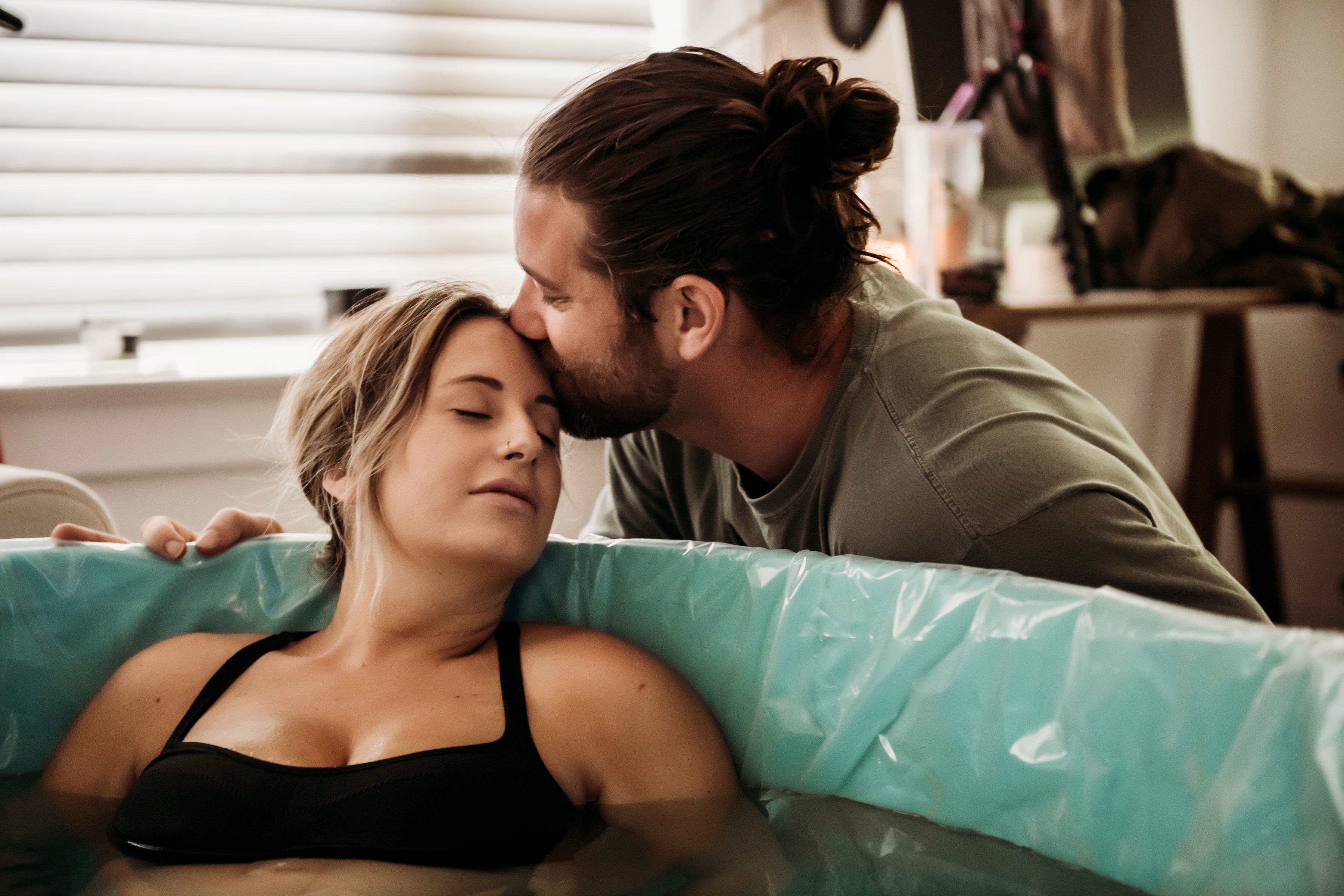 Mother in birthtub being comforted by father. Mother in birthtub being comforted by father.